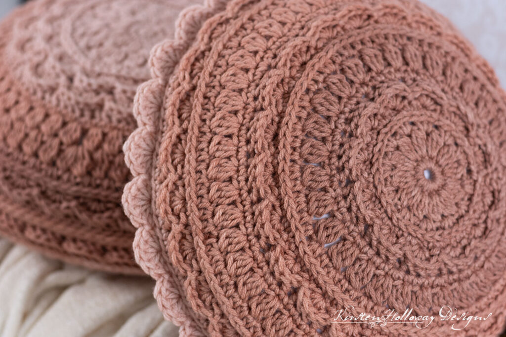 Close up stitch detail of 2 round crochet pillows,